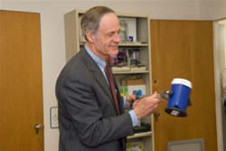 Photo of Tom Carper holding a large mug with a gripper